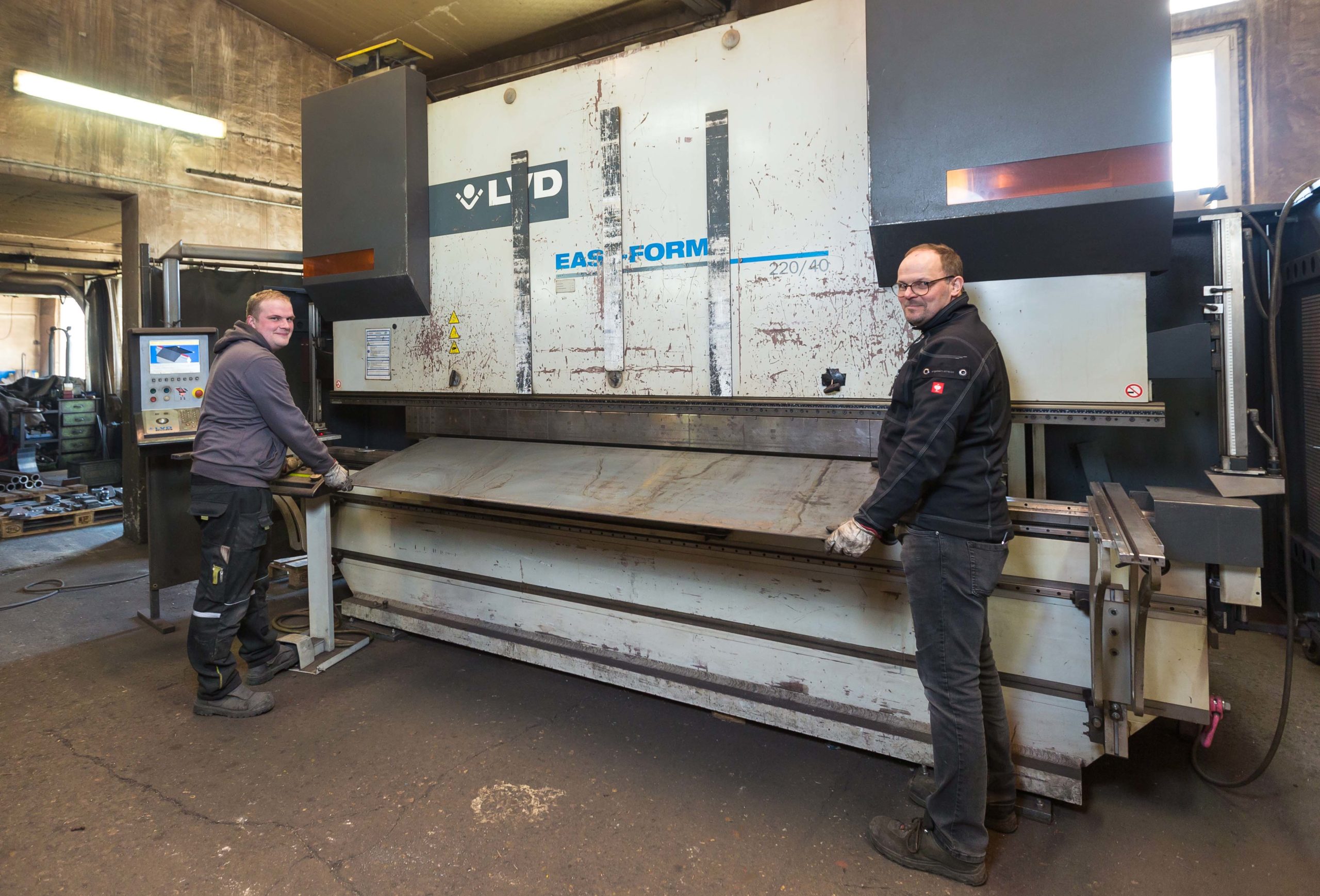 Der 27-jährige Steven Göbel (links), der seine Ausbildung zum Metallbauer bei Hesse Metalltechnik gemacht hat, und Betriebsleiter Markus Sträter arbeiten an einer Umformmaschine.
