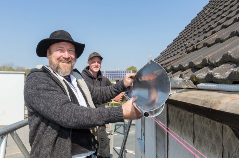 Gemeinsam hängen Inhaber Thomas Gutwin (links) und Dachdecker Yves Viert eine Dachrinne ein, damit sie anschließend verlötet werden kann.