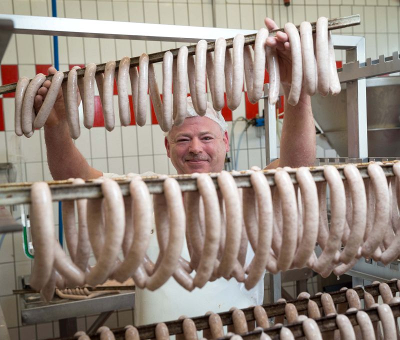 Wolfgang Galinski hängt Bratwürste zum Räuchern auf - Traumberufe Fleischer und Fachverkäufer 2023