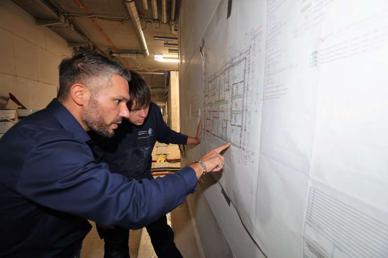 Talat Akbulut und Cedrick Prätsch schauen sich den Schaltplan eines Gebäudes an - Traumberufe Elektroniker und Informationselektroniker 2023