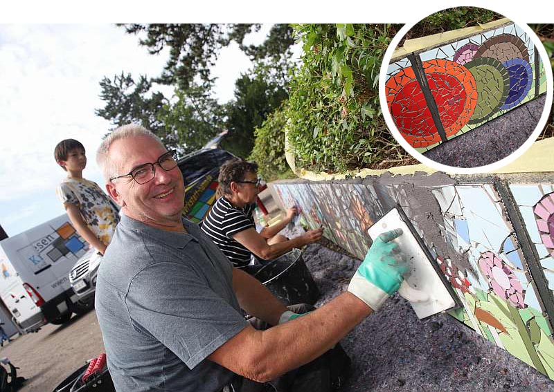 Martin Kraski unterstützt seine Frau bei einem Mauer-Mosaik am Freiherr-vom-Stein-Gymnasium - Traumberufe Fliesen-, Platten- und Mosaikleger 2023