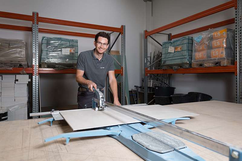 Marcel Vogt schneidet in der Werkstatt eine Fliesenplatte - Traumberufe Fliesen-, Platten- und Mosaikleger 2023