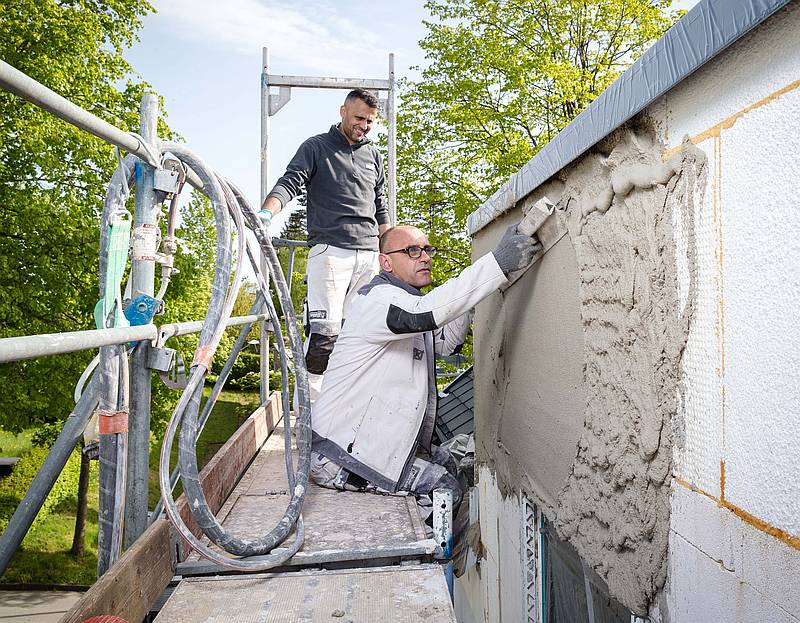 Jacek Siekierkowski (vorne) zieht den Leichtunterarmierputz glatt, den Hasan Weli (hinten) gerade aufgetragen hat. Foto: Gabi Bender