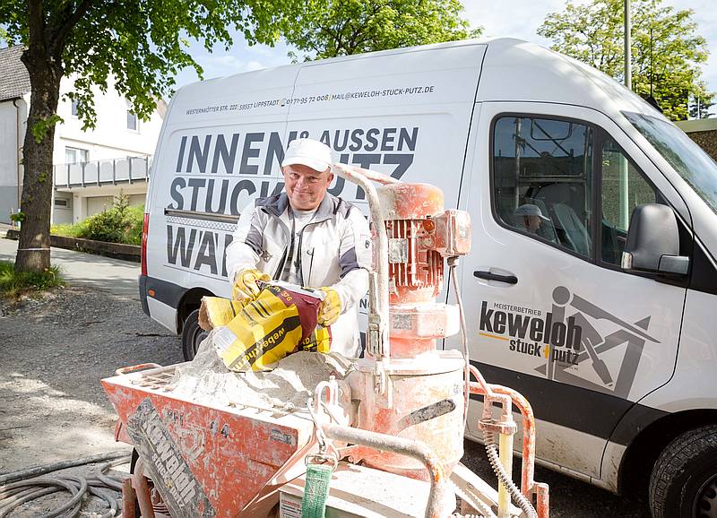 Zbiegniew Siekierkowski schüttet einen mineralischen Armierungsmörtel in die Putzmaschine. Foto: Gabi Bender