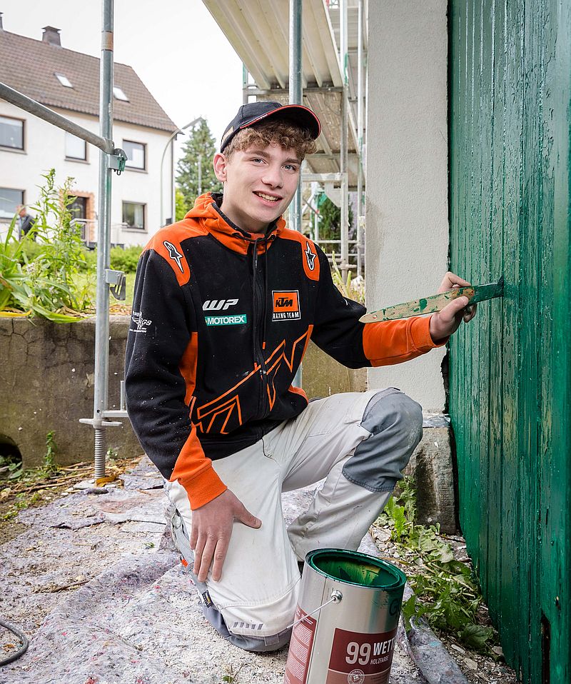 Mike Schmitz streicht ein Scheunentor - Ausbildung Maler 2024 Soest