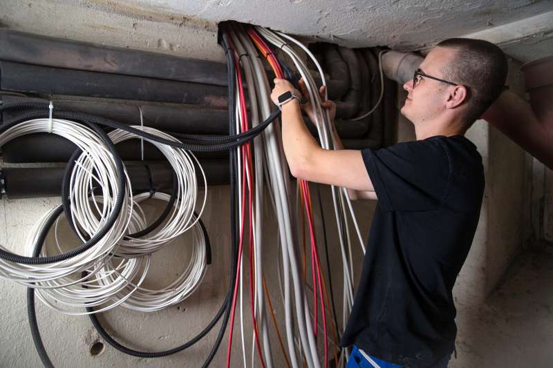 In einem Altbau in Soest verlegt der Auszubildende Fabian Immich, der derzeit im vierten Lehrjahr ist, neue Zuleitungen zur Zählerverteilung. (Foto: Gabi Bender)