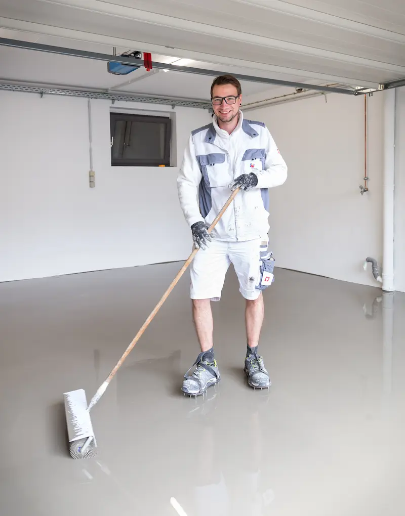 Magnus Modes fährt mit einer Entlüftungswalze über den neu gemachten Bodenbelag. Traumberufe Maler 2026