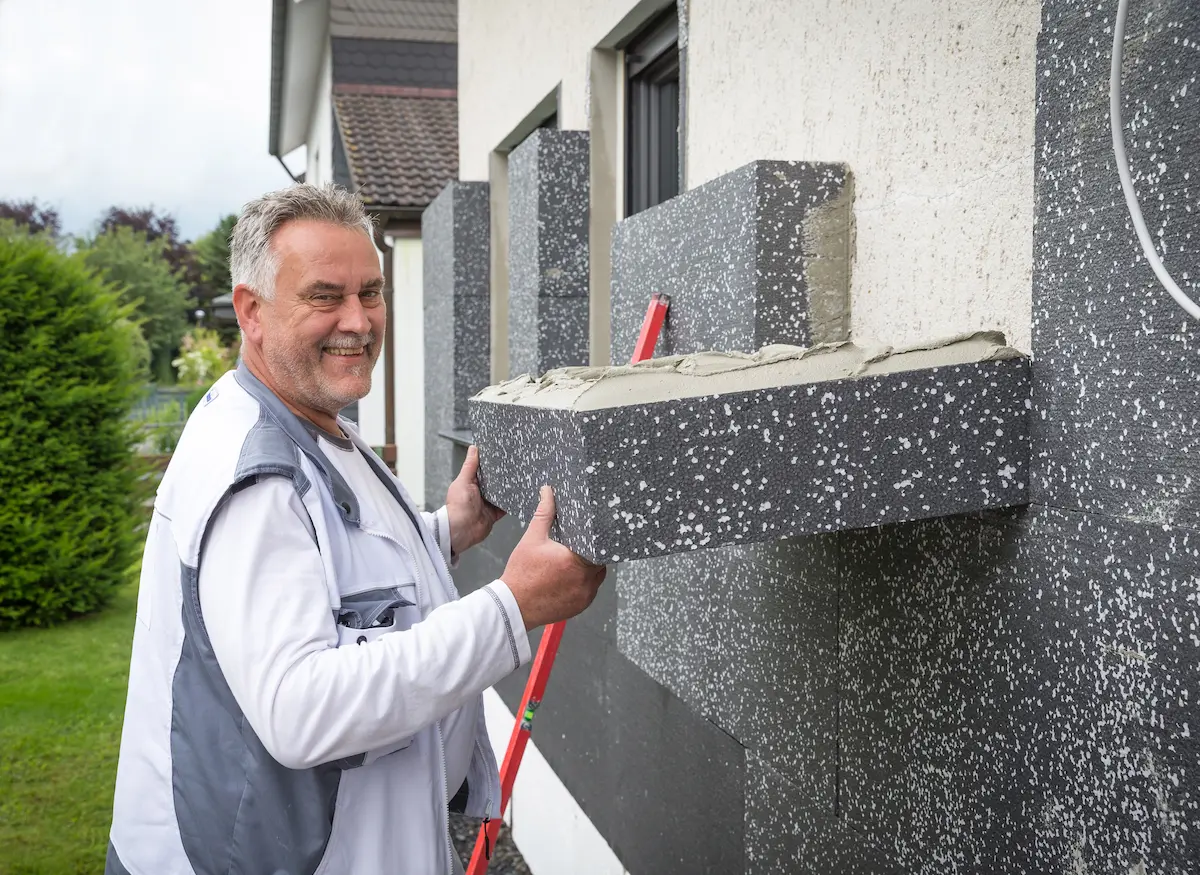 Ralf „Ralle“ Bicke klebt Styroporplatte an die Außenwand eines Hauses. Traumberufe Maler 2026