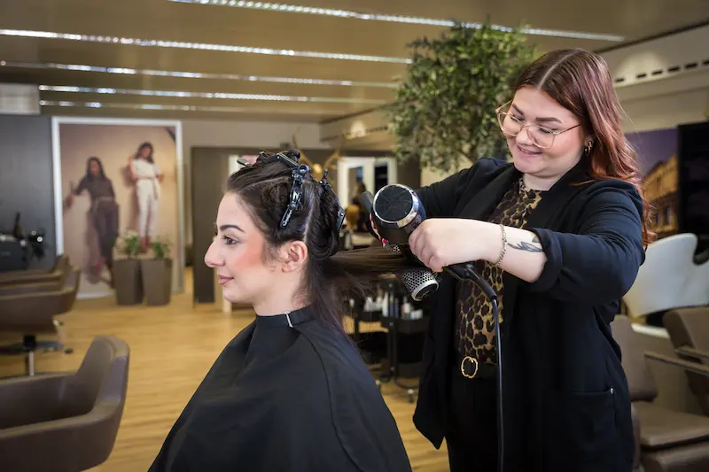 Kim Novoselac stylt die Haare einer Kundin. Traumberufe Friseur 2026