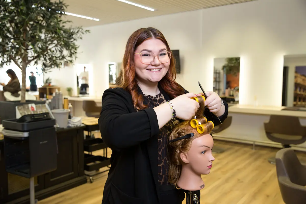 Kim Novoselac übt an einem Puppenkopf. Traumberufe Friseur 2026