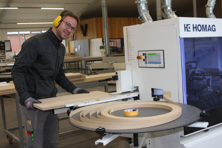 Elias Ramm, Auszubildender im ersten Jahr, beim so genannten Anfahren einer Massivholzkante an einer modernen Kantenanleimmaschine. (Foto: Helga Wissing)