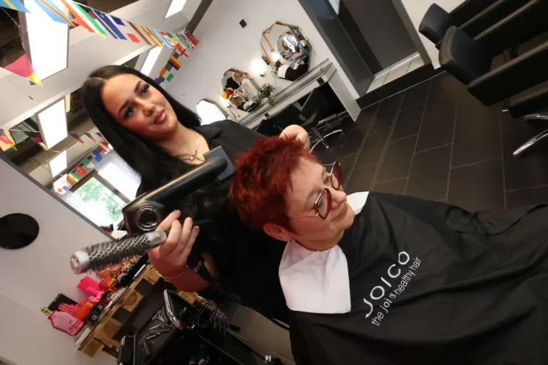 Nadine Mohammed f&ouml;hnt die Haare einer Kundin. Traumberufe Friseur 2026