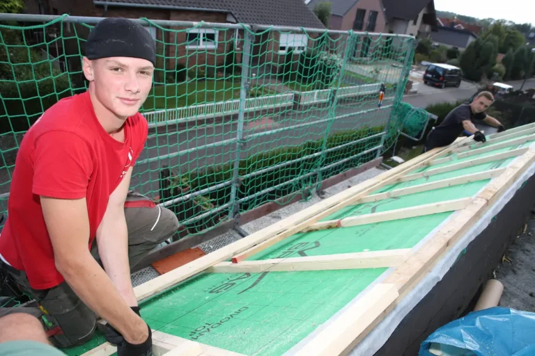 Ole Nelle richtet Materialien auf dem Dach aus, mithilfe einer Richtschnur. Traumberufe Dachdecker 2026