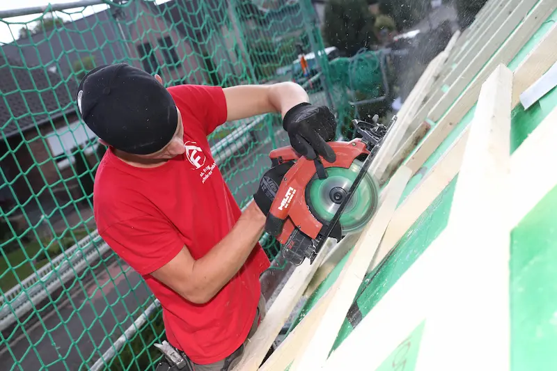 Ole Nelle schneidet eine Dachlatte nach Maß. Traumberufe Dachdecker 2026