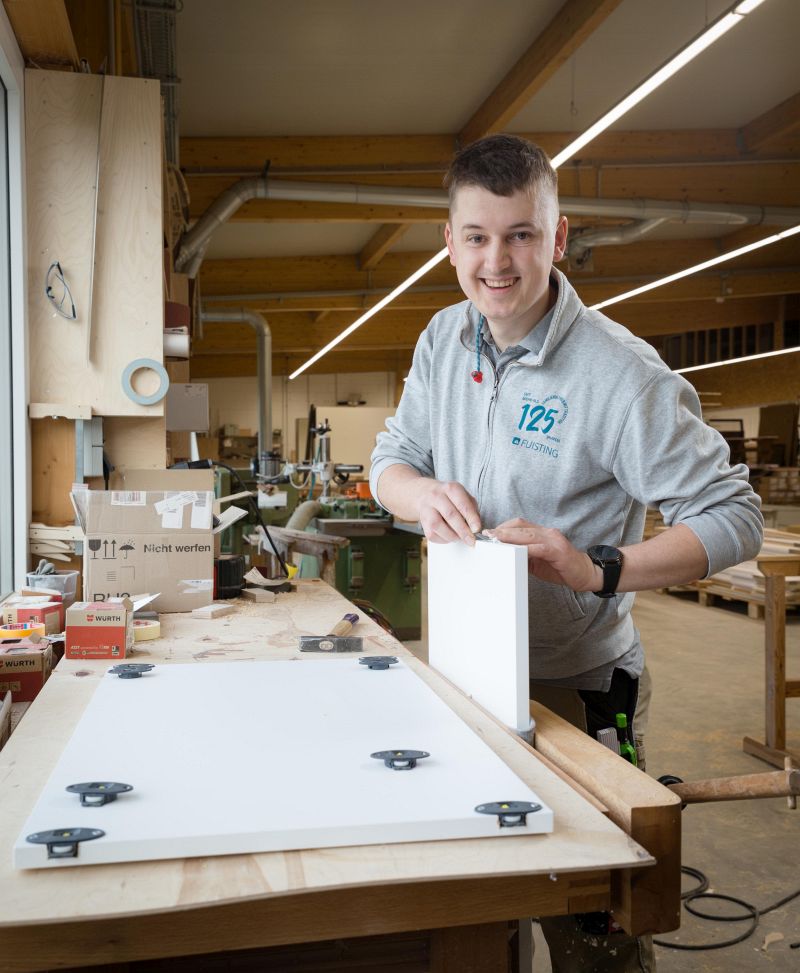 Der Tischlermeister entgratet die Kanten der Nut - Traumberufe Tischler 2023