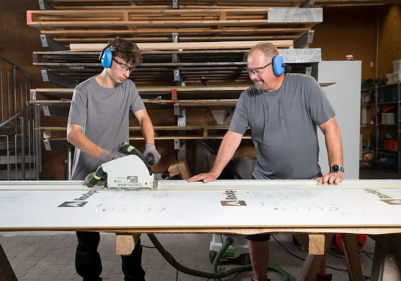 Michele Ziesmann sägt eine Rockpanelplatte für eine Fassade auf Maß. Traumberufe Dachdecker 2026
