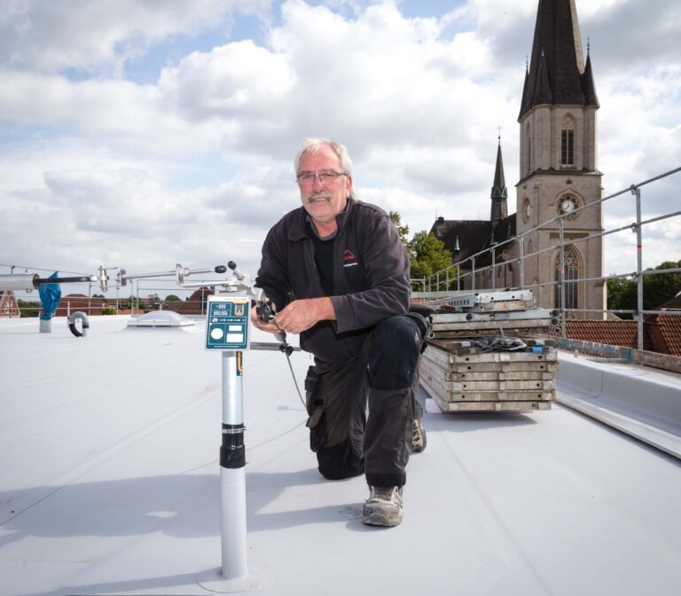 Hubert Willenbrink, Geschäftsführer des von ihm 2001 gegründeten Handwerksbetriebes, spannt auf dem Flachdach eines mehrstöckigen Gewerbeobjektes ein Seil für ein Seilsicherungssystem, an dem man sich unter anderem bei späteren Wartungsarbeiten angurten kann. Fotos: Gabi Bender
