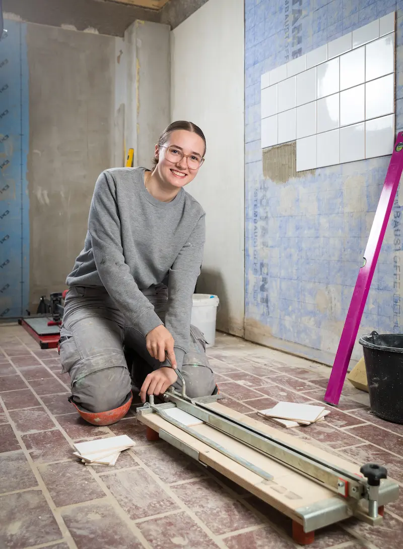Laura Ramsel schneidet Fliesen mit einer Schneidemaschine. Traumberufe Fliesenleger 2026