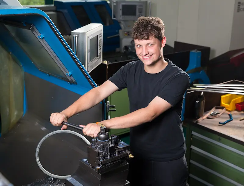 Luca Hansen tauscht ein Werkzeug an einer CNC-gesteuerten Drehmaschine aus. Traumberufe Feinwerkmechaniker 2026