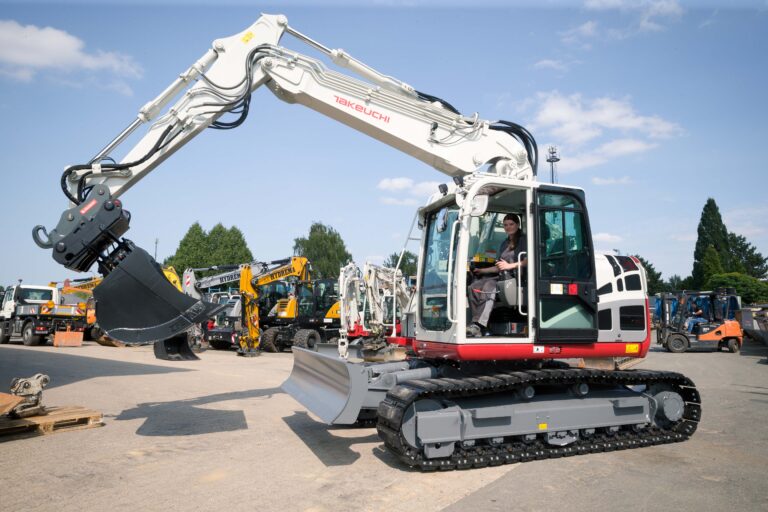 Mit einem Bagger der Firma Takeuchi fährt Emily Ryan, die bei der Erwentraut GmbH die Ausbildung zur Land- und Baumaschinenmechatronikerin macht, über das Firmengelände des Familienunternehmens. Foto: Gabi Bender