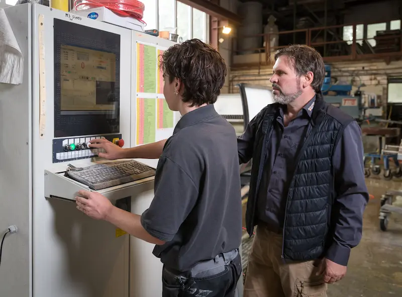 Christian Schütte (links) und Karsten Schütte programmieren die CNC-gesteuerte Fräse. Traumberufe Steinmetz 2026
