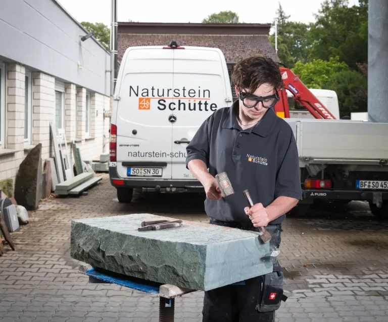 Christian Schütte bearbeitet einen Stein mit Hammer und Meißel. Traumberufe Steinmetz 2026
