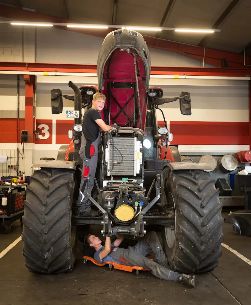 Justus Ense (oben) und Felix Schnitker reparieren einen Traktor. Traumberufe Land- und Baumaschinenmechatroniker 2026