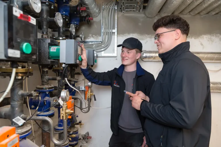 Emanuel Mihu (rechts) zeigt dem Azubi Piet Bremen, wie er mit dem Smartphone die Heizungsanlage programmieren kann. Traumberufe 2026 Anlagenmechaniker f&uuml;r SHK