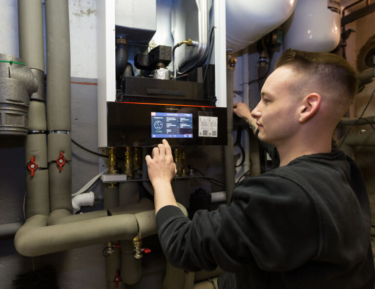 Lukas Riepe bedient das Display der modernen Wärmepumpe - Traumberuf Sanitär 2025