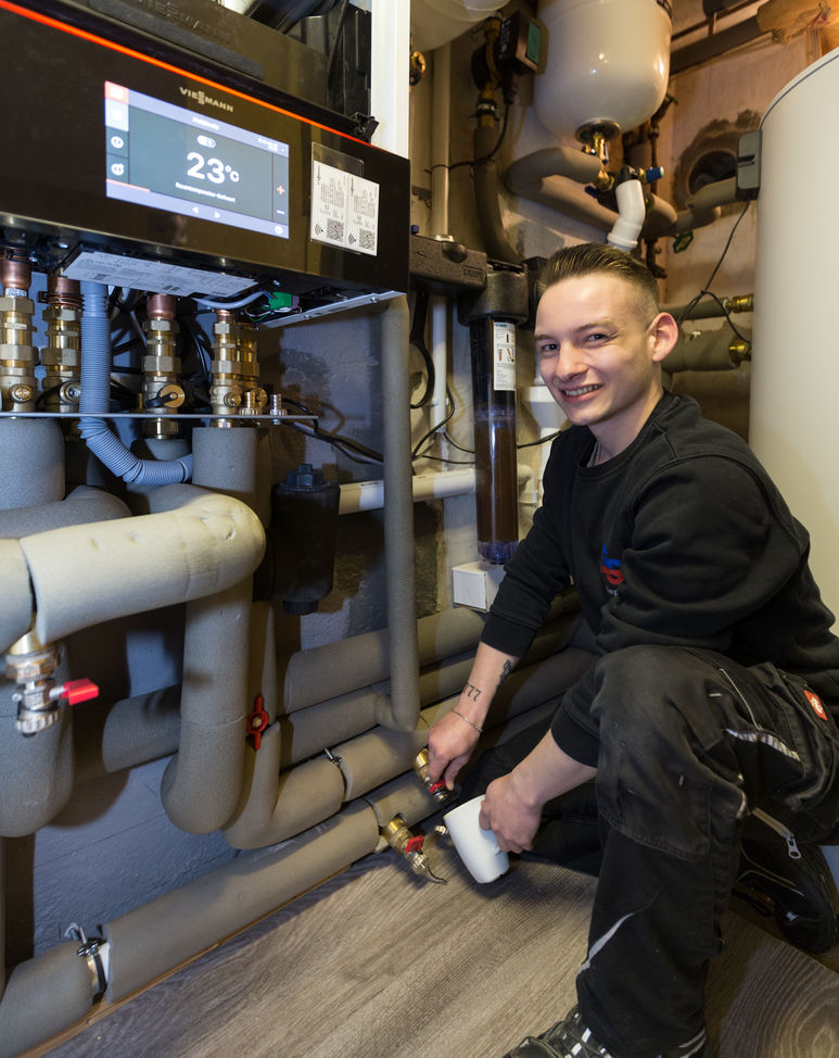 Lukas Riepe nimmt im Rahmen einer Wärmepumpenwartung eine Wasserprobe - Traumberuf Sanitär 2025