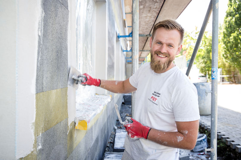 Robin Kinscher putzt mit einem Glätter ein Fenster bei einem Gewerbeobjekt ein - Traumberuf Stuckateur 2025