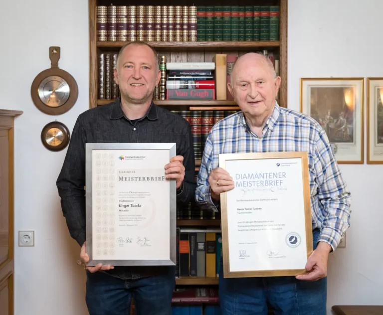 Tischlermeister Franz Tuneke (rechts) und sein Sohn Gregor Tuneke (links) halten ihre Meisterbriefe hoch. Traumberufe Tischler 2026