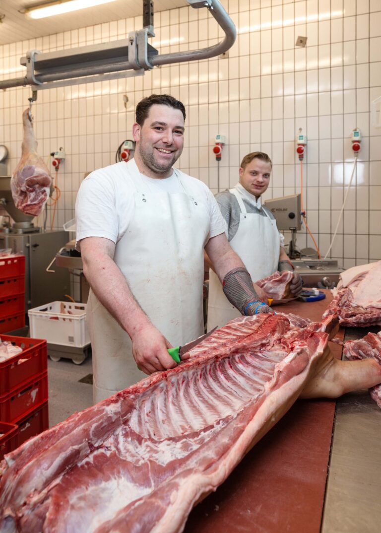 Mit einem Ausbeinmesser lösen Peter Taprogge (vorne) und Mark Rennebaum das Fleisch von den Knochen eines Schweins. Foto: Gabi Bender