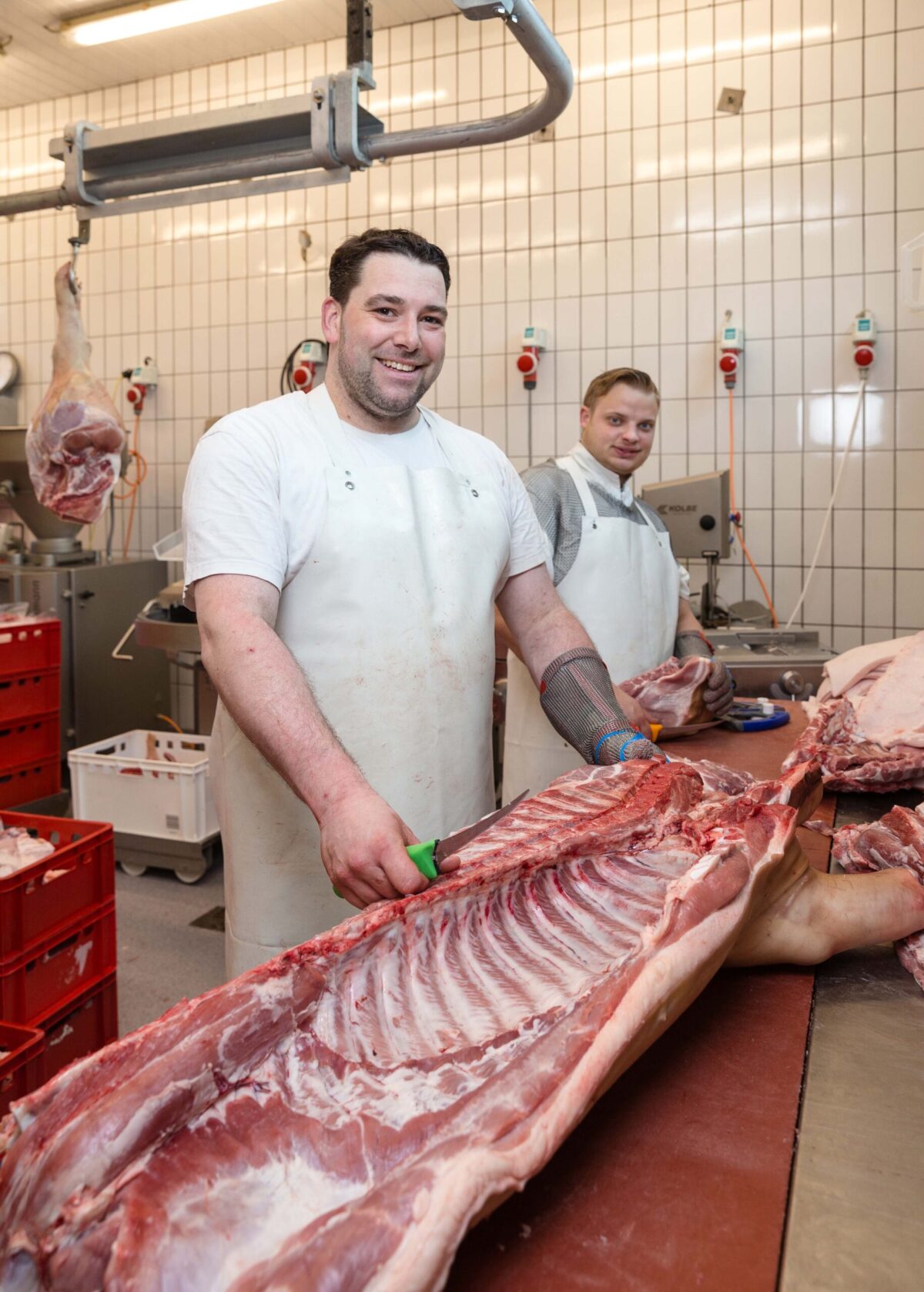 Mit einem Ausbeinmesser lösen Peter Taprogge (vorne) und Mark Rennebaum das Fleisch von den Knochen eines Schweins. Foto: Gabi Bender