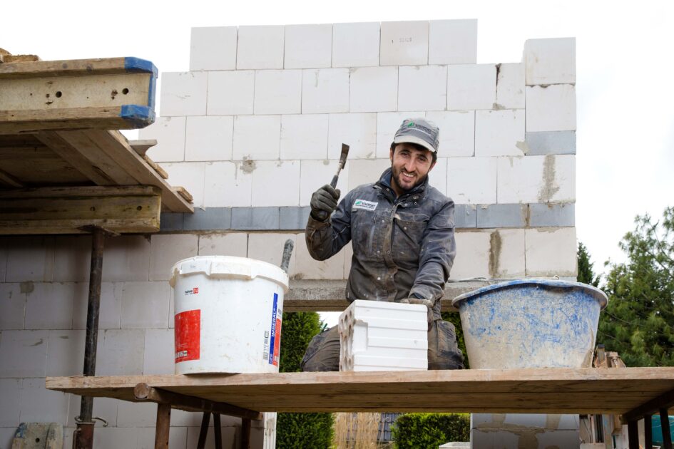 Auf einer Baustelle in Lendringsen bearbeitet Wahdatullah Nasery einen Kalksandstein mit einem Maurerhammer. Foto: Gabi BenderAuf einer Baustelle in Lendringsen bearbeitet Wahdatullah Nasery einen Kalksandstein mit einem Maurerhammer. Foto: Gabi Bender