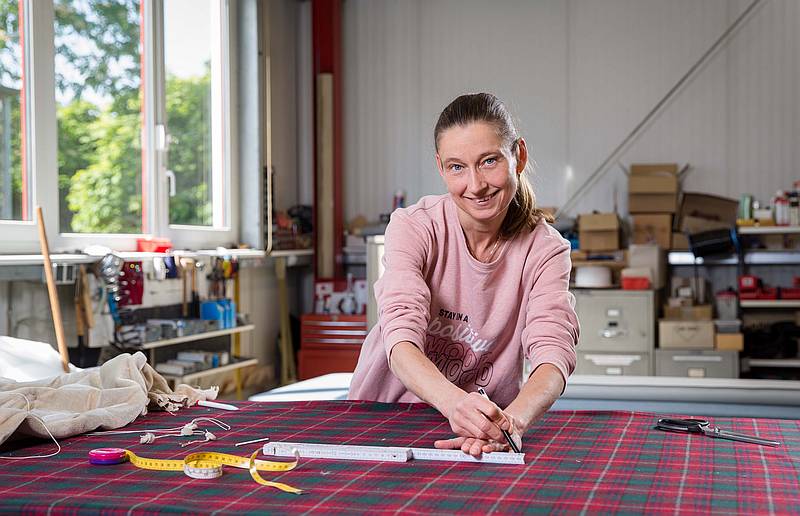 Stephanie Esselmann markiert die Stellen für die Knöpfe auf dem Stoff - Traumberufe Raumausstatter, Sattler und Schneider 2024