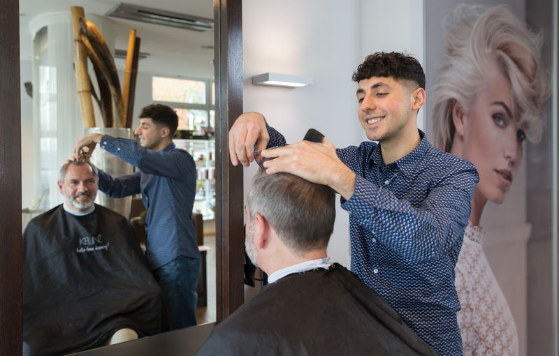 Milad David schneidet die Haare des Kunden - Ausbildung zum Friseur 2025