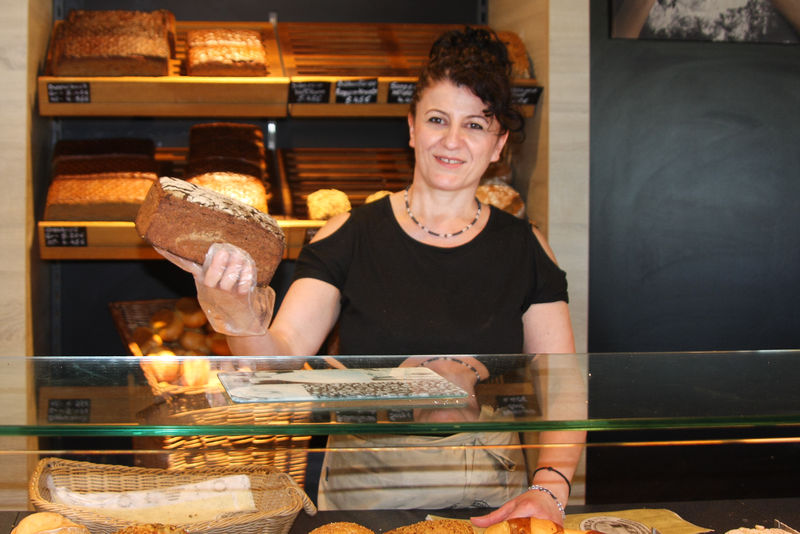 Mirella Mbostaraku hält ein Brot hinter der Bäckertheke - Traumberuf Bäcker 2025