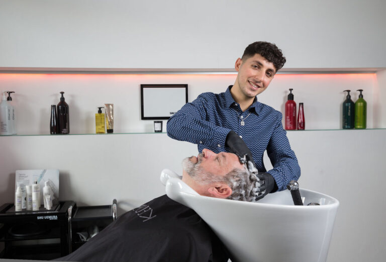 Milad David wäscht die Haare des Kunden - Ausbildung zum Friseur 2025