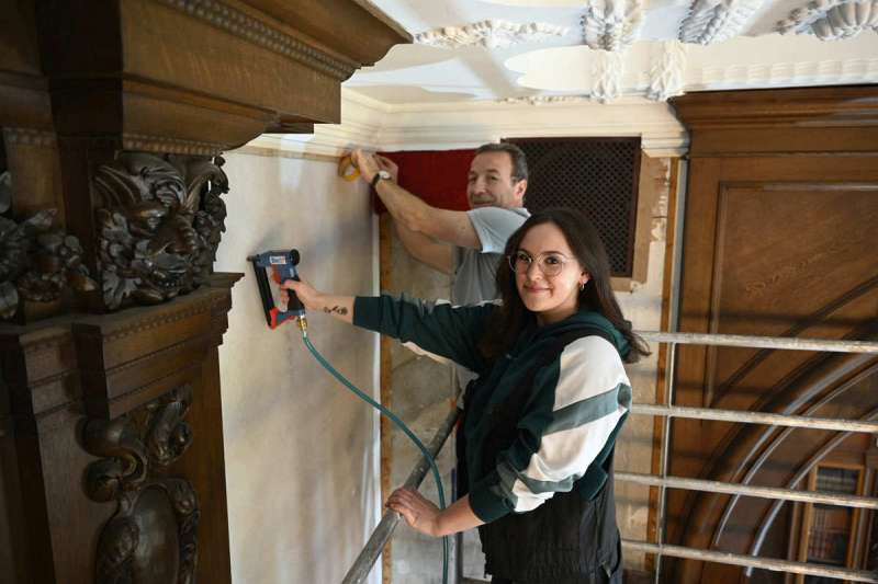 Arnsberg-Herdringen, der Raumausstattermeister Clemens Köhler und seine Auszubildende Dana-Ann Teutenberg bringen Stoffbahnen an die Wände des Jagdschlosses Herdringen an - Traumberufe Raumausstatter, Sattler und Schneider 2023