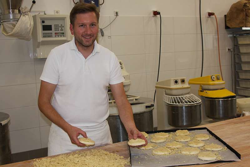 Bäckermeister Benjamin Redder belegt die süßen Hefeteig-Taler mit Streuseln - Traumberufe Bäcker, Konditor und Fachverkäufer im Lebensmittelhandwerk 2023