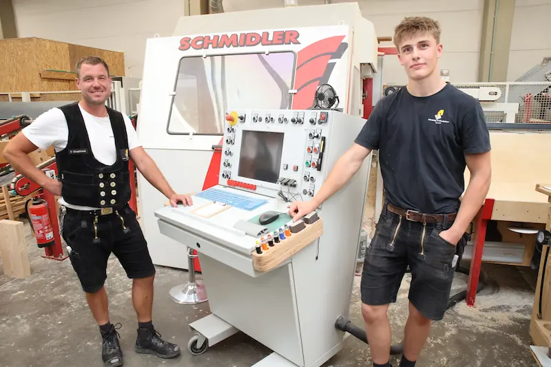 Lehrherr Adrian Schröder (links) und Azubi Thorben Stadermann (rechts) vor einer CNC-Maschine. Traumberufe Zimmerer 2026