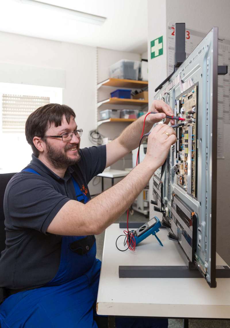 Eric Eckmann messt die Strom und Spannung bei einzelnen Komponenten eines Fernsehers - Traumberufe Elektroniker und Informationselektroniker 2023