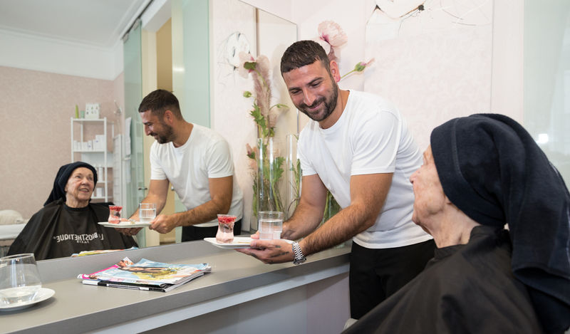 Rosario Fallea bringt Erfrischungsgetränk zur Kundin - Traumberufe Friseur 2025 Soest